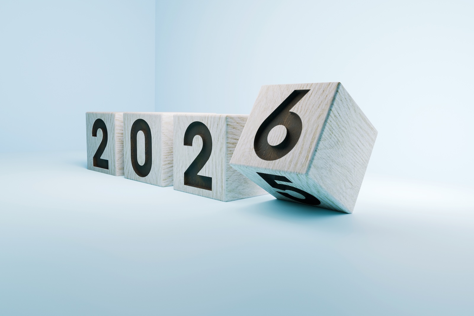 Wooden blocks showing the transition from 2025 to 2026, symbolizing the new year, change, and future planning on a light minimalist background. 2026, creative idea. 2025 turns into 2026, concept